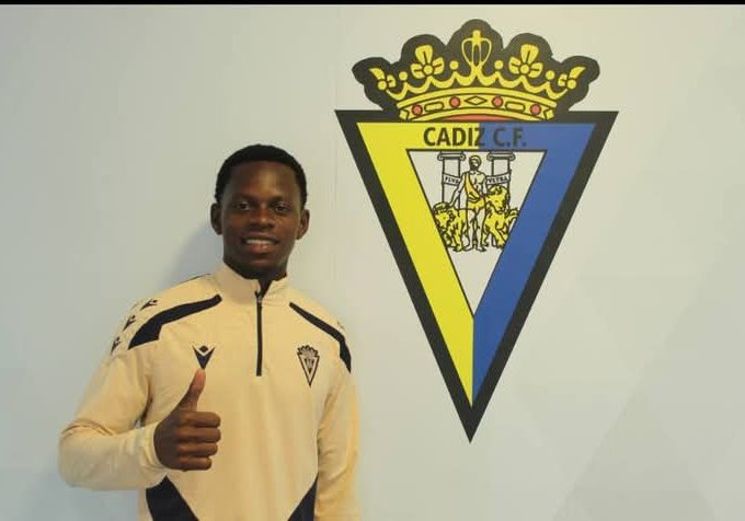 Mbemba posing next to Cadiz Fc Logo Upon signing a 4 year deal